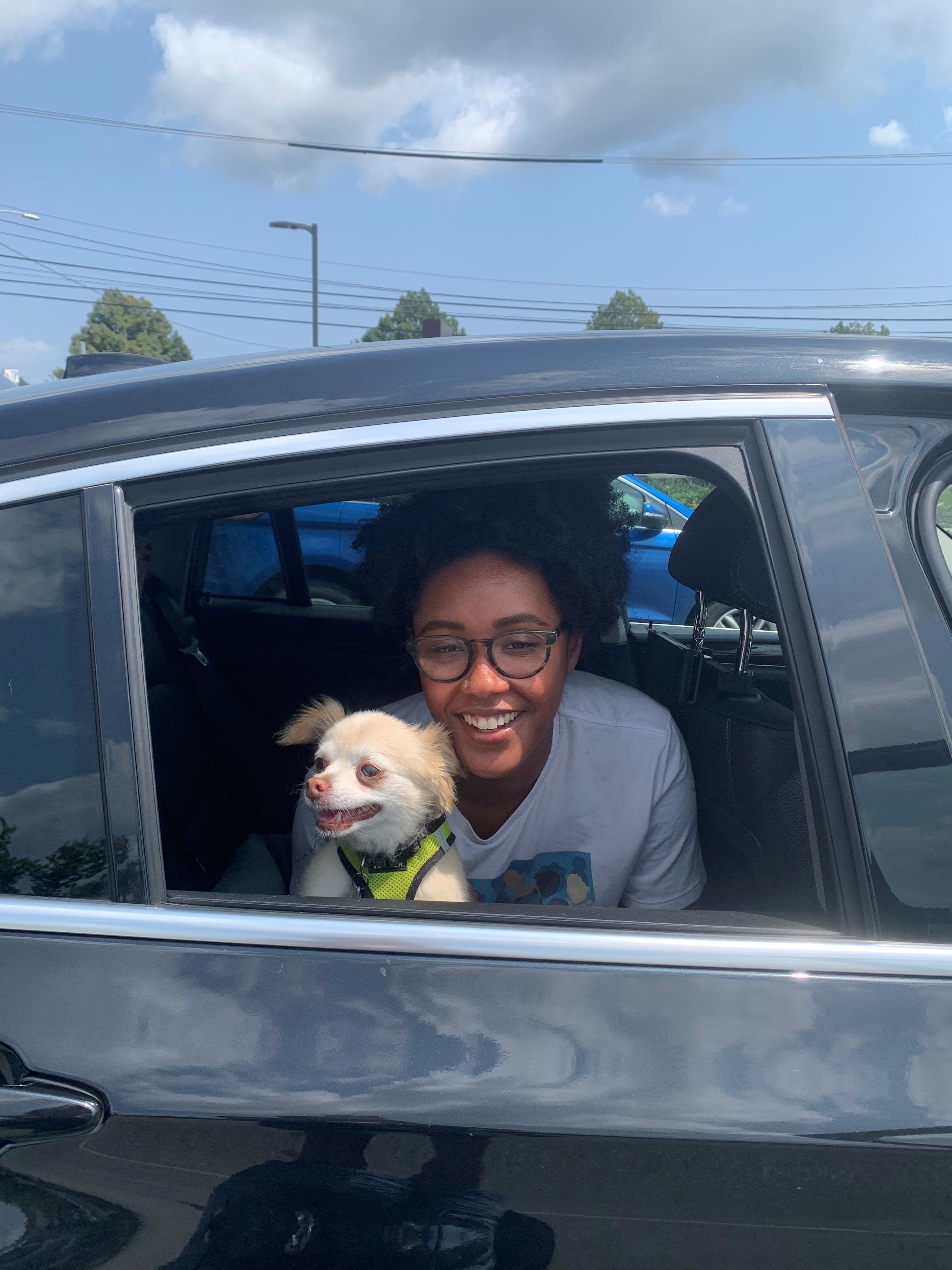 Blair Dixon looking out car window with dog