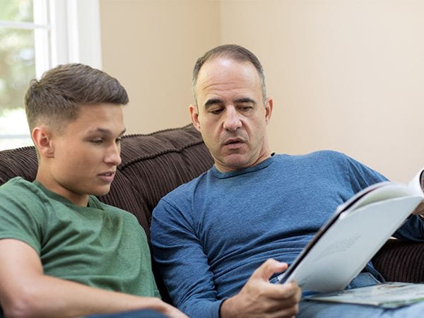 Dad and son talking about a paper